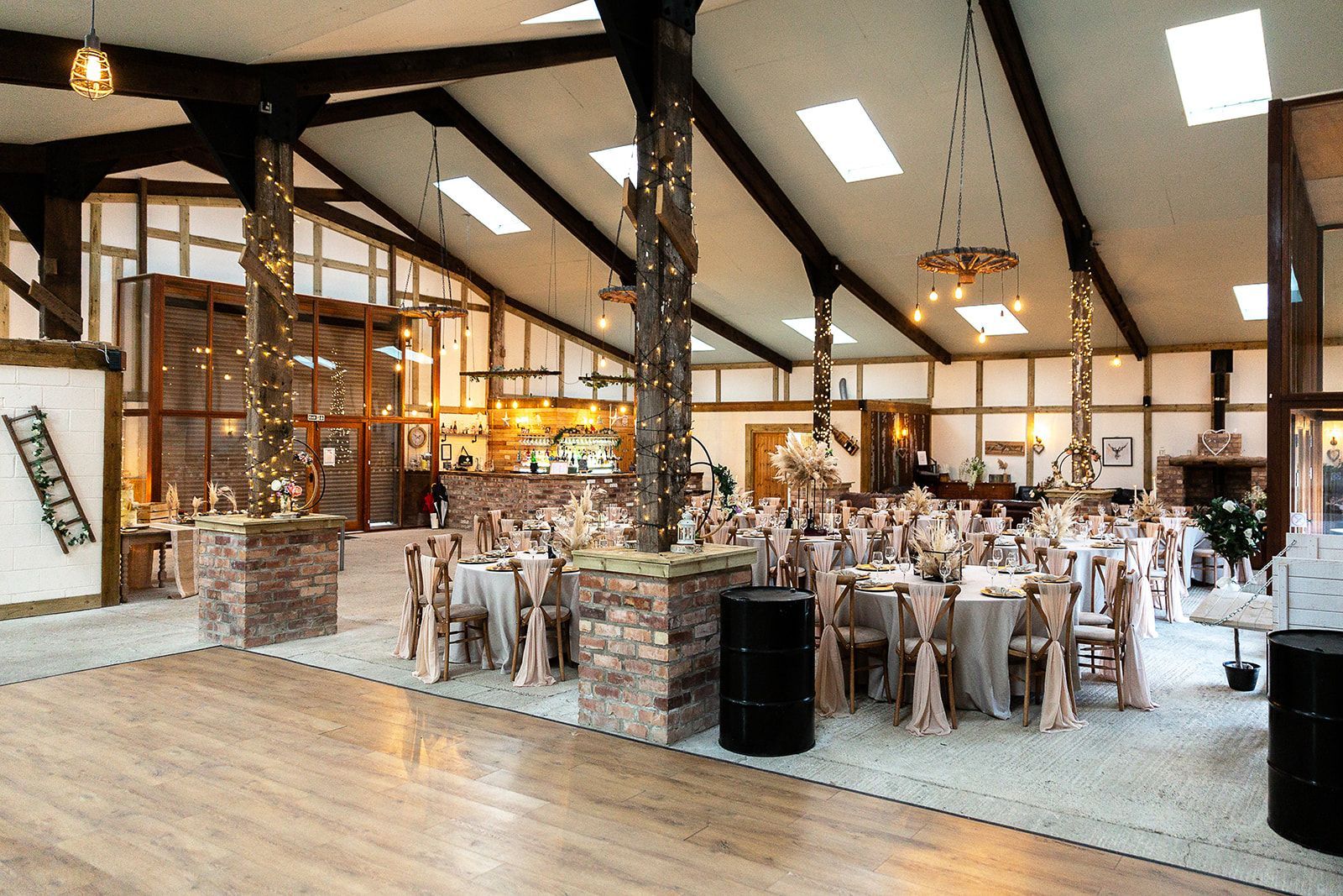 A large room with tables and chairs set up for a wedding reception.