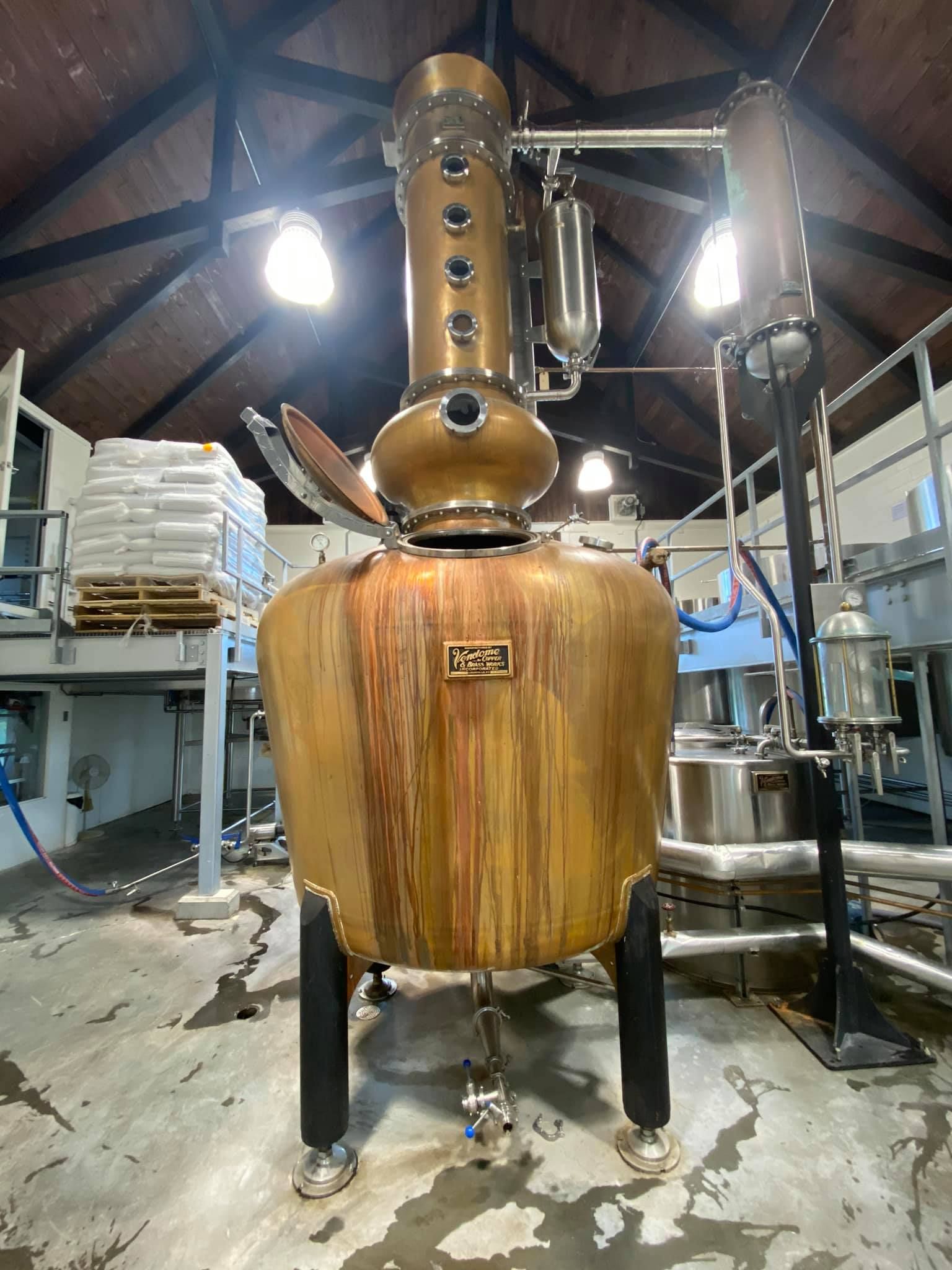 Une grande distillerie de cuivre se trouve à l'intérieur d'un bâtiment.
