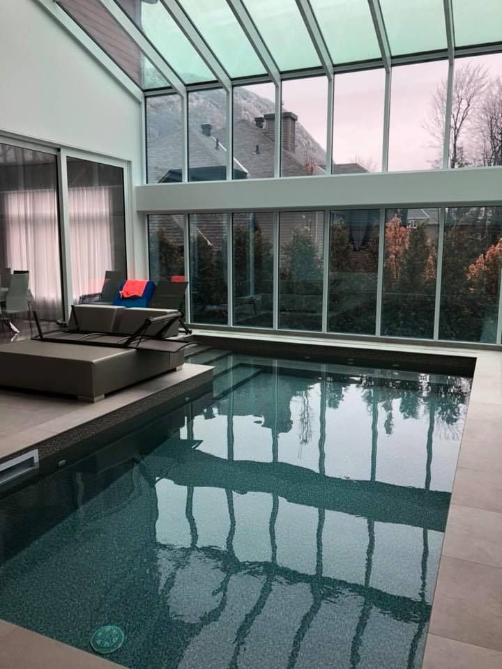 Une grande piscine intérieure avec beaucoup de fenêtres
