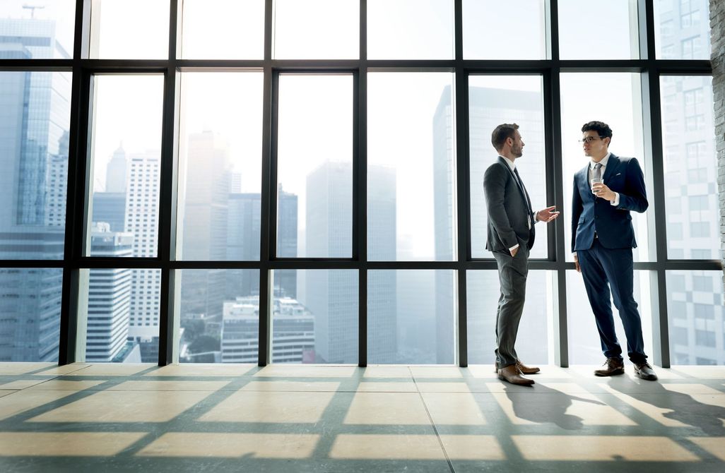 two men standing next to each other with their arms crossed