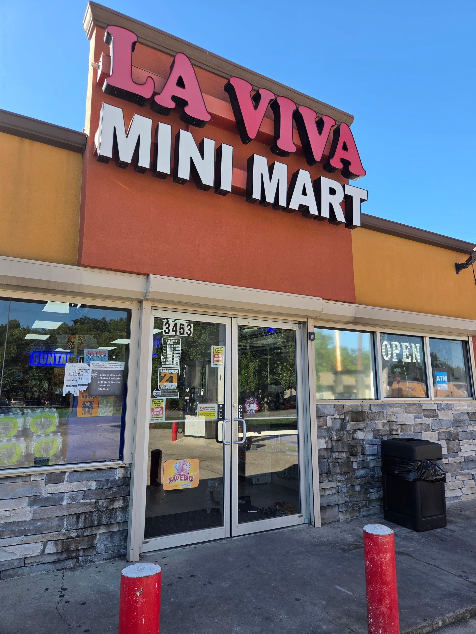 La Viva Mini Mart storefront with glass doors, orange facade, and red bollards