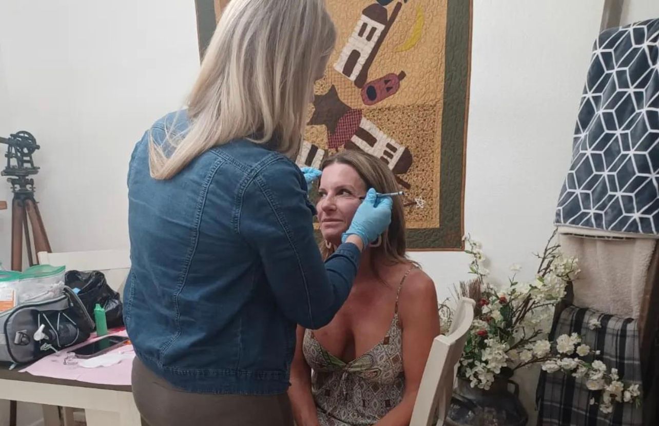 Jordana injecting botox into a womans face 