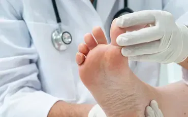 A doctor is examining a patient 's foot with a stethoscope.