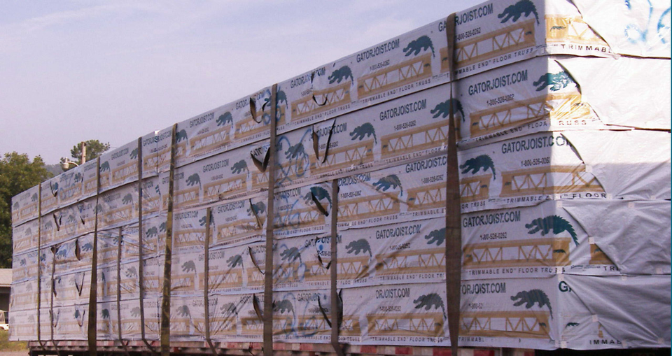 Wooden house framing with exposed beams and studs inside a construction site