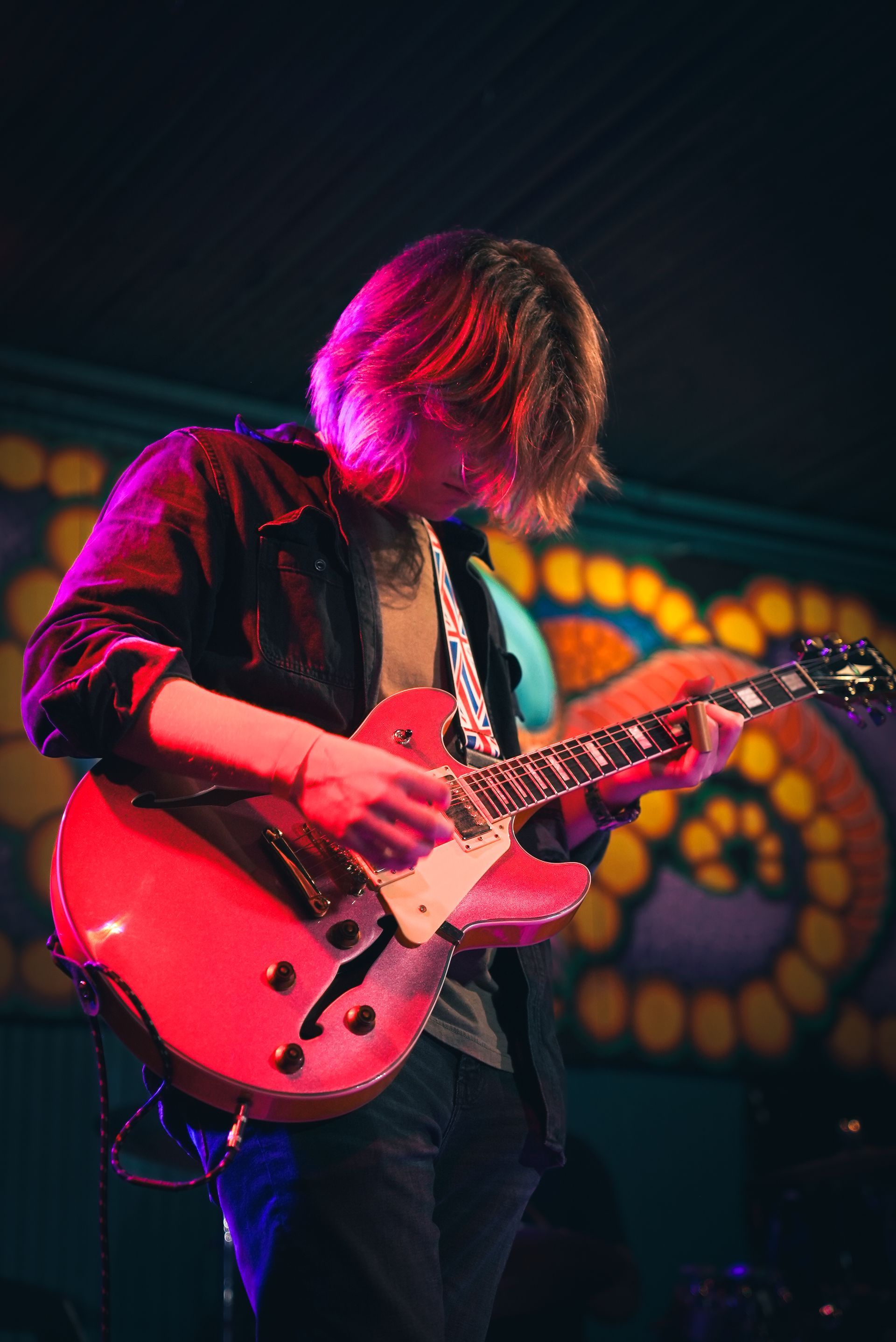 Close up of a guitar player playing at a live concert.
