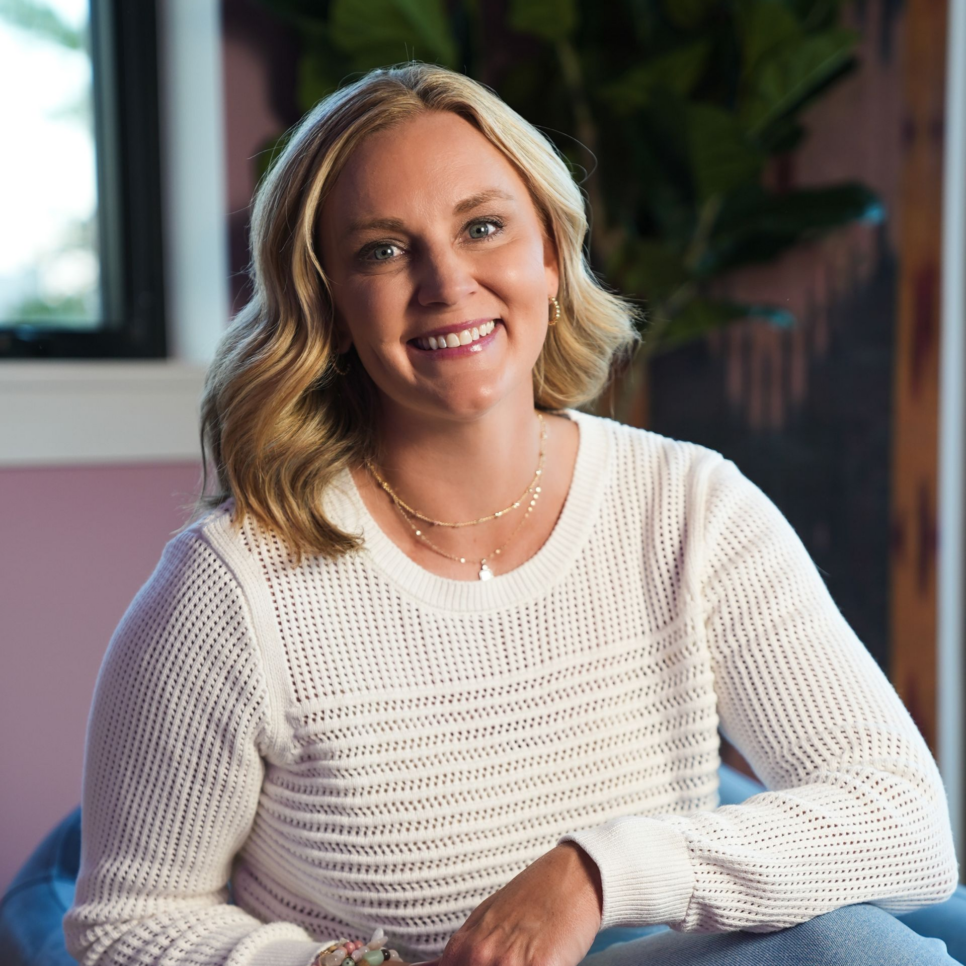 Professional headshot of a woman in a colorful room.