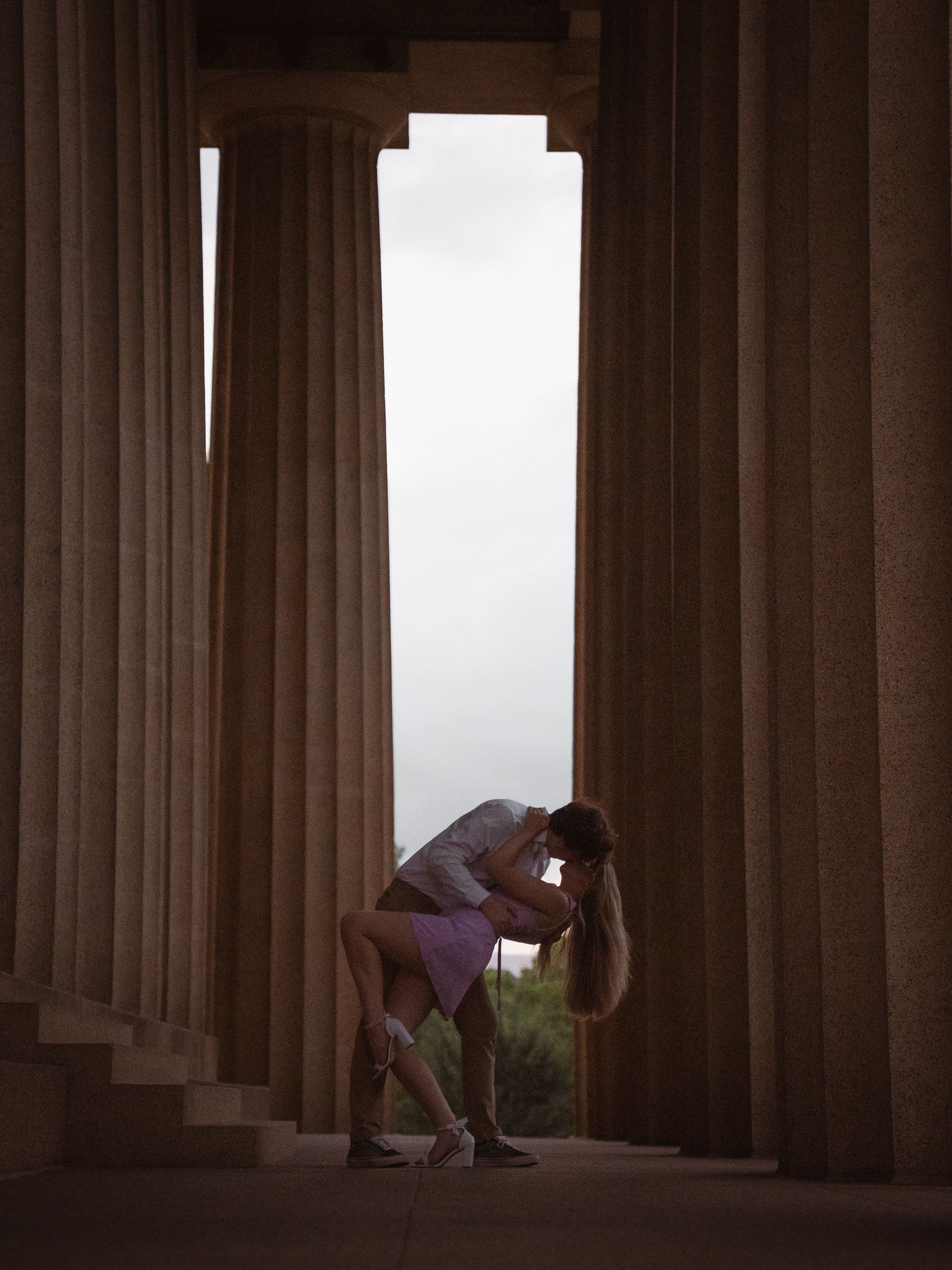 A recently engaged couple dips for a kiss in the Parthenon in Nashville, Tennessee.