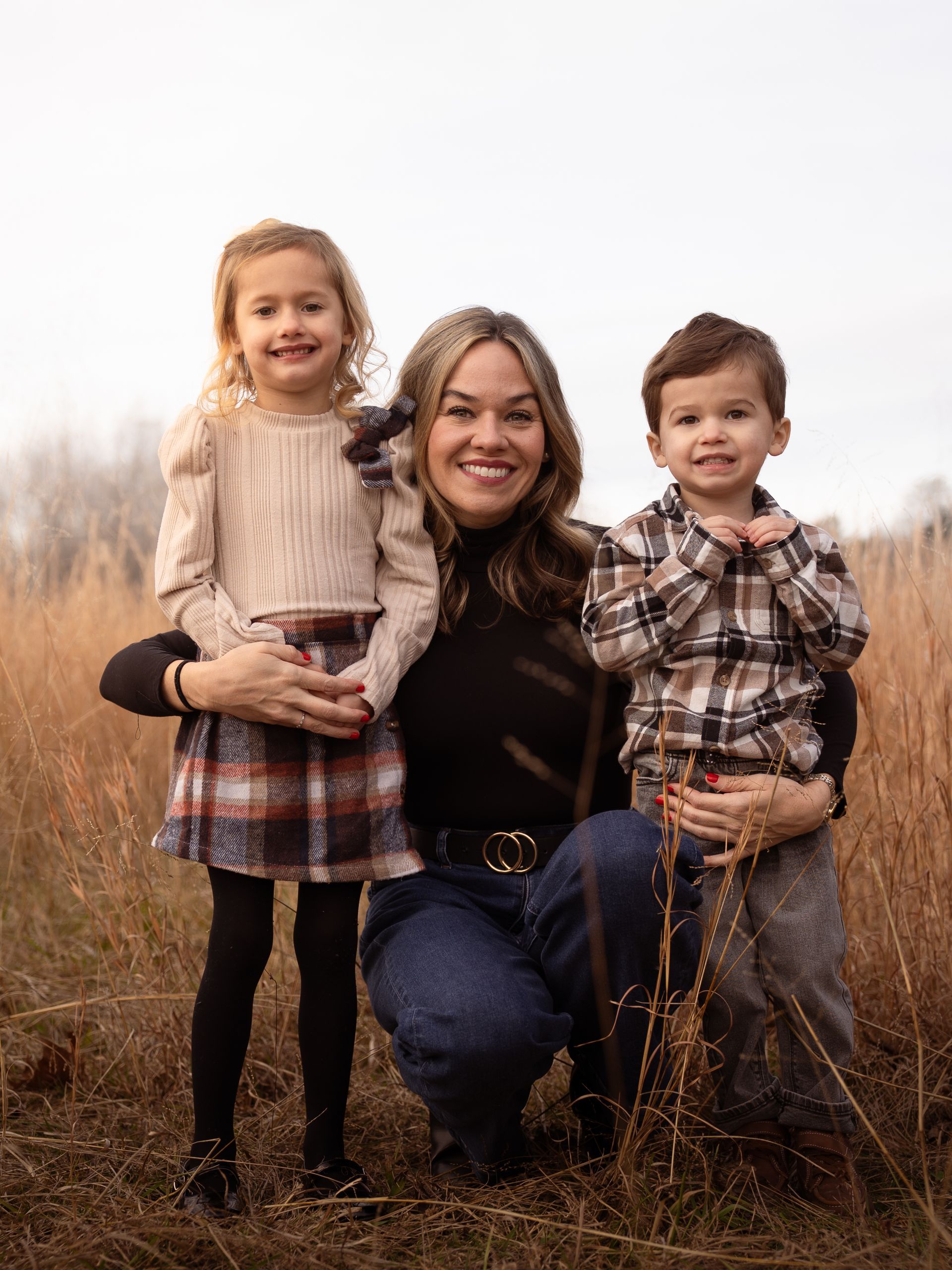 A mother and her young kids pose together for family photos.