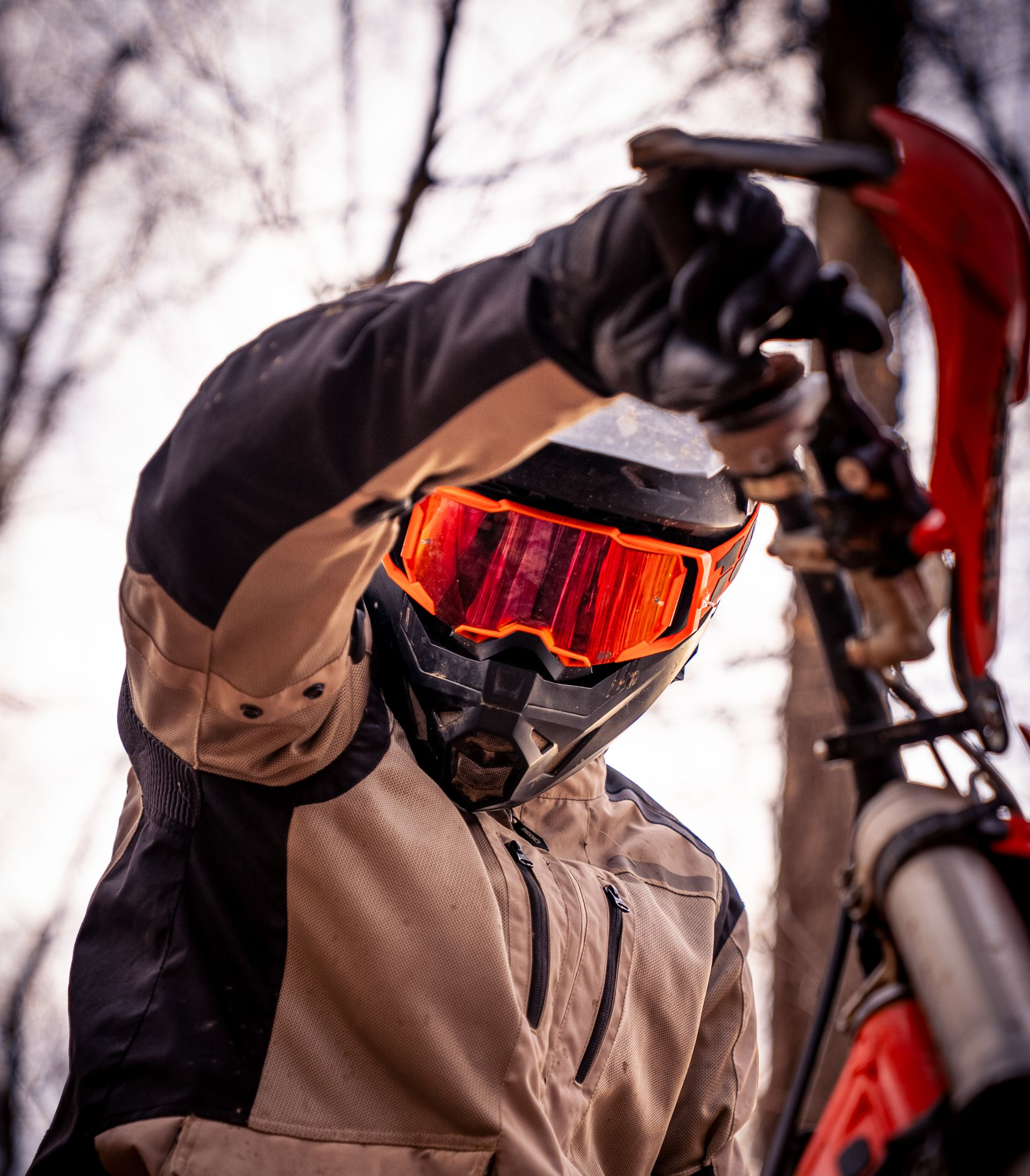 Close up of a boy riding a dirt bike and looking down at the camera for senior photos.