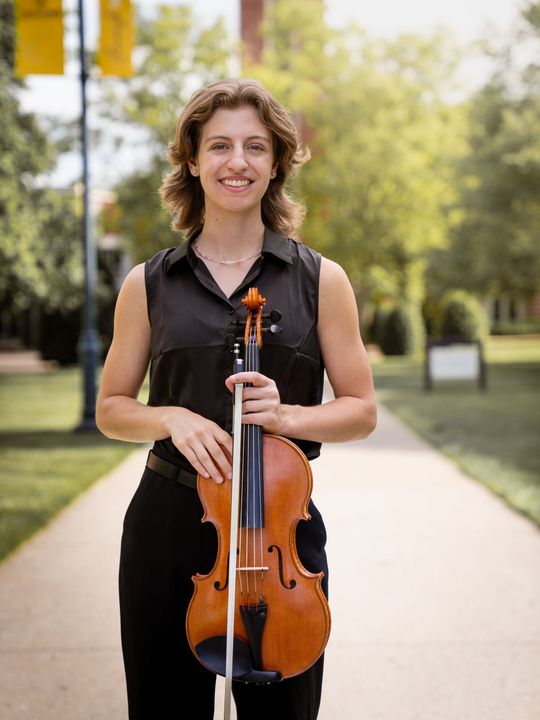 Full body headshot of a girl holding a viola.