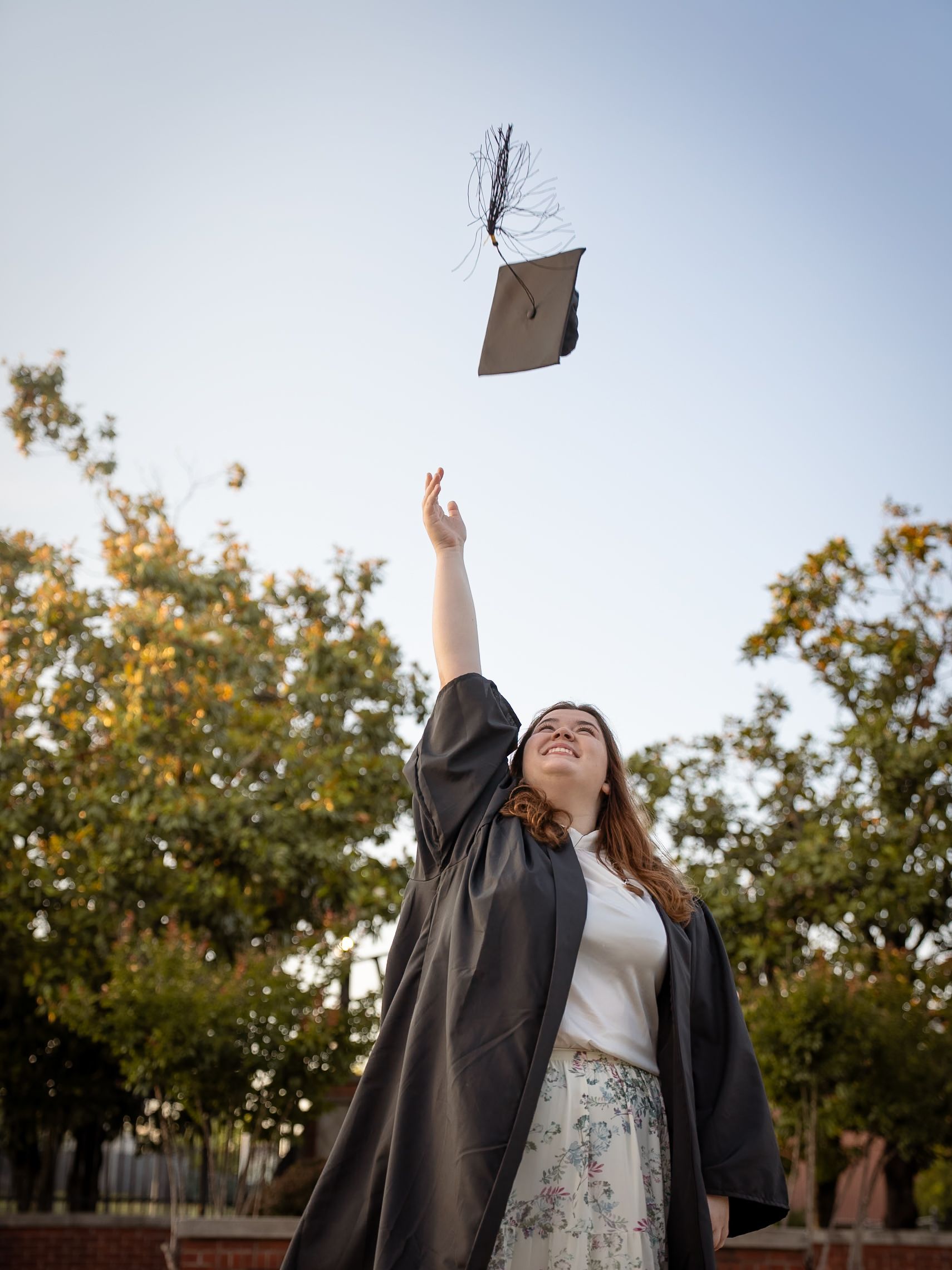 Woman throwing a graduation cap into the air.