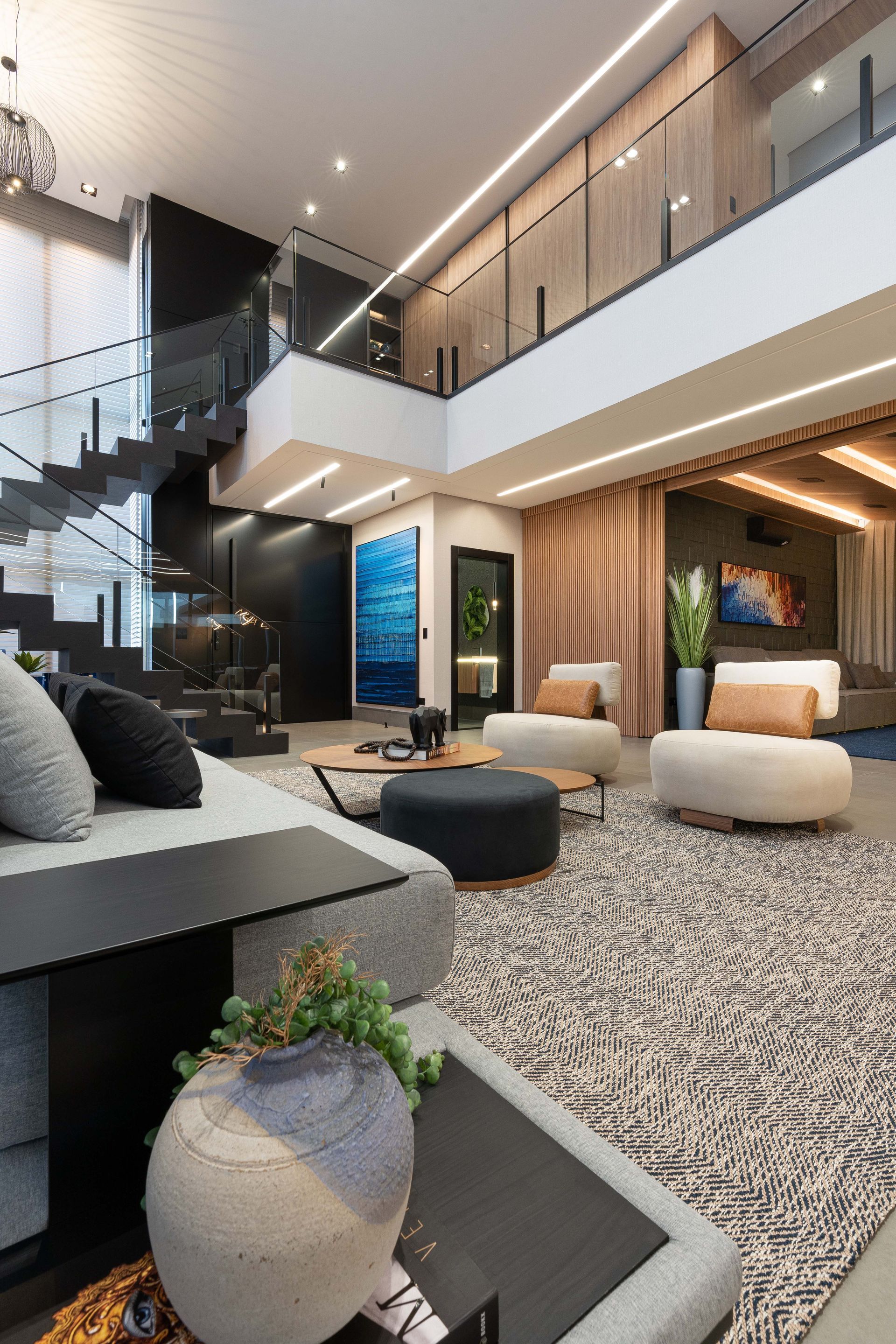 Sala de estar moderna com escada, layout aberto e cores neutras.