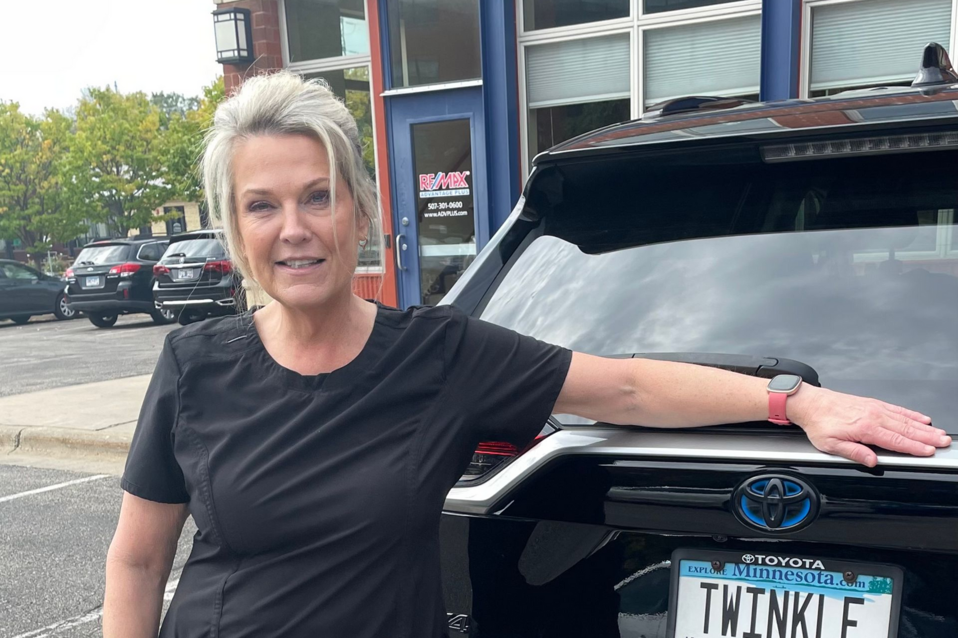 Nurse Laurie is leaning on a black Toyota SUV with a personalized “TWINKLE” license plate.