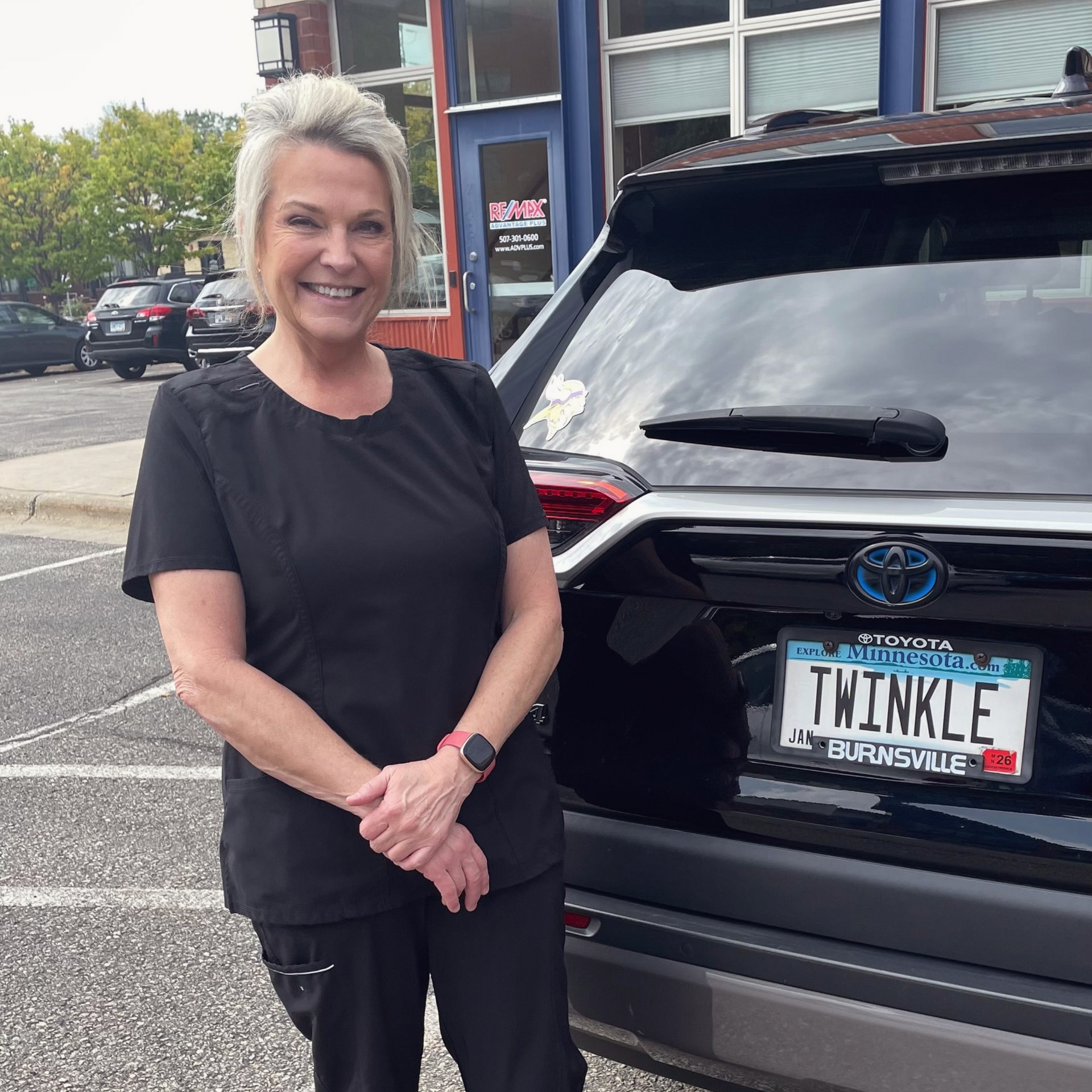 Nurse Laurie standing next to a black SUV.