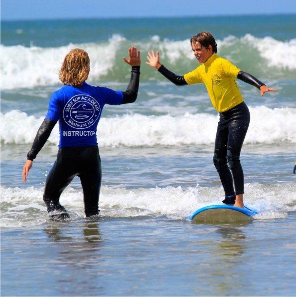 SurfSUP instructors in the water at Westward Ho! teaching surfing. A perfect beach to learn to surf.
