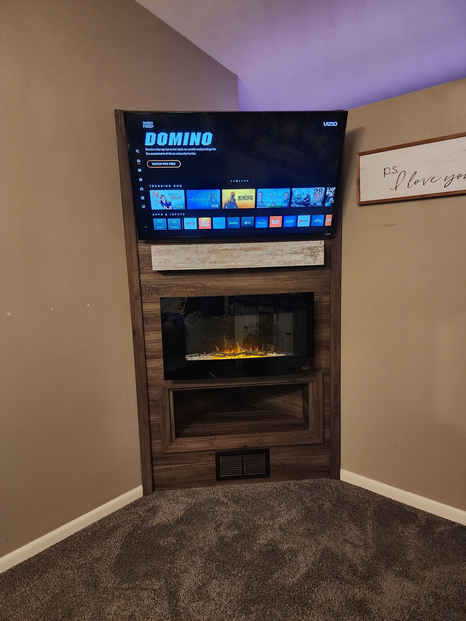 A living room with a fireplace and a flat screen tv.