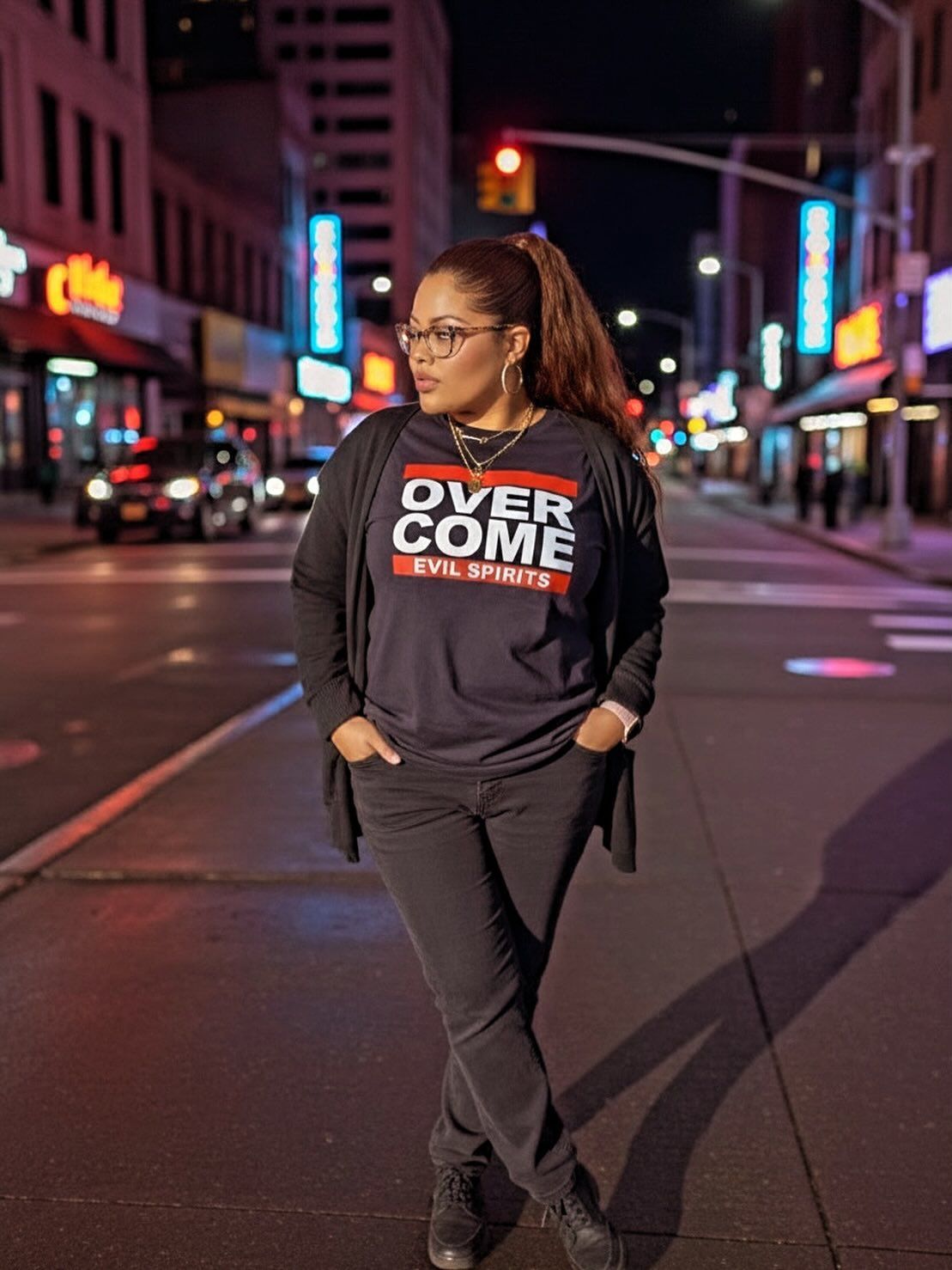 Woman standing in a city street at night, wearing a black sweatshirt and glasses, with neon lights in the background