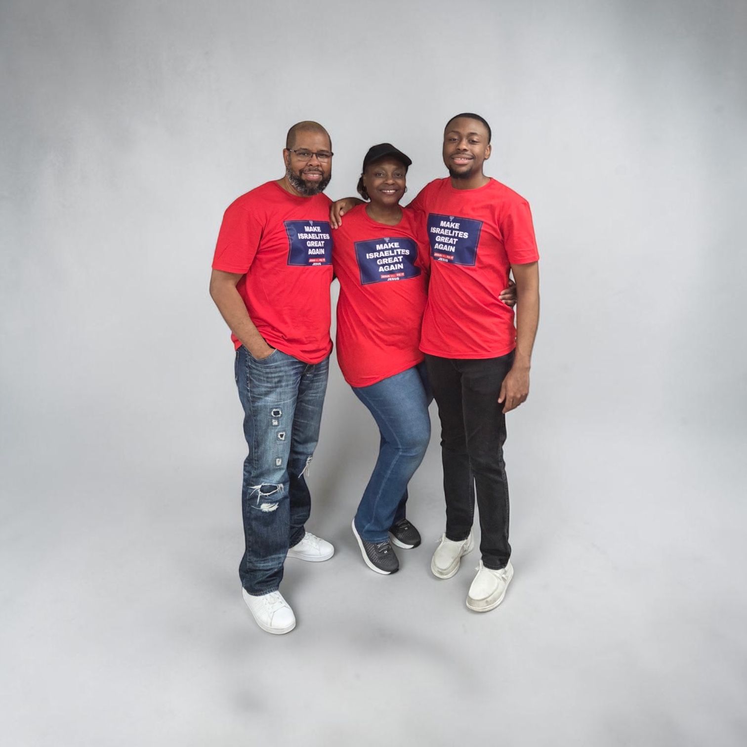 Three people in red shirts posing together against a gray studio backdrop