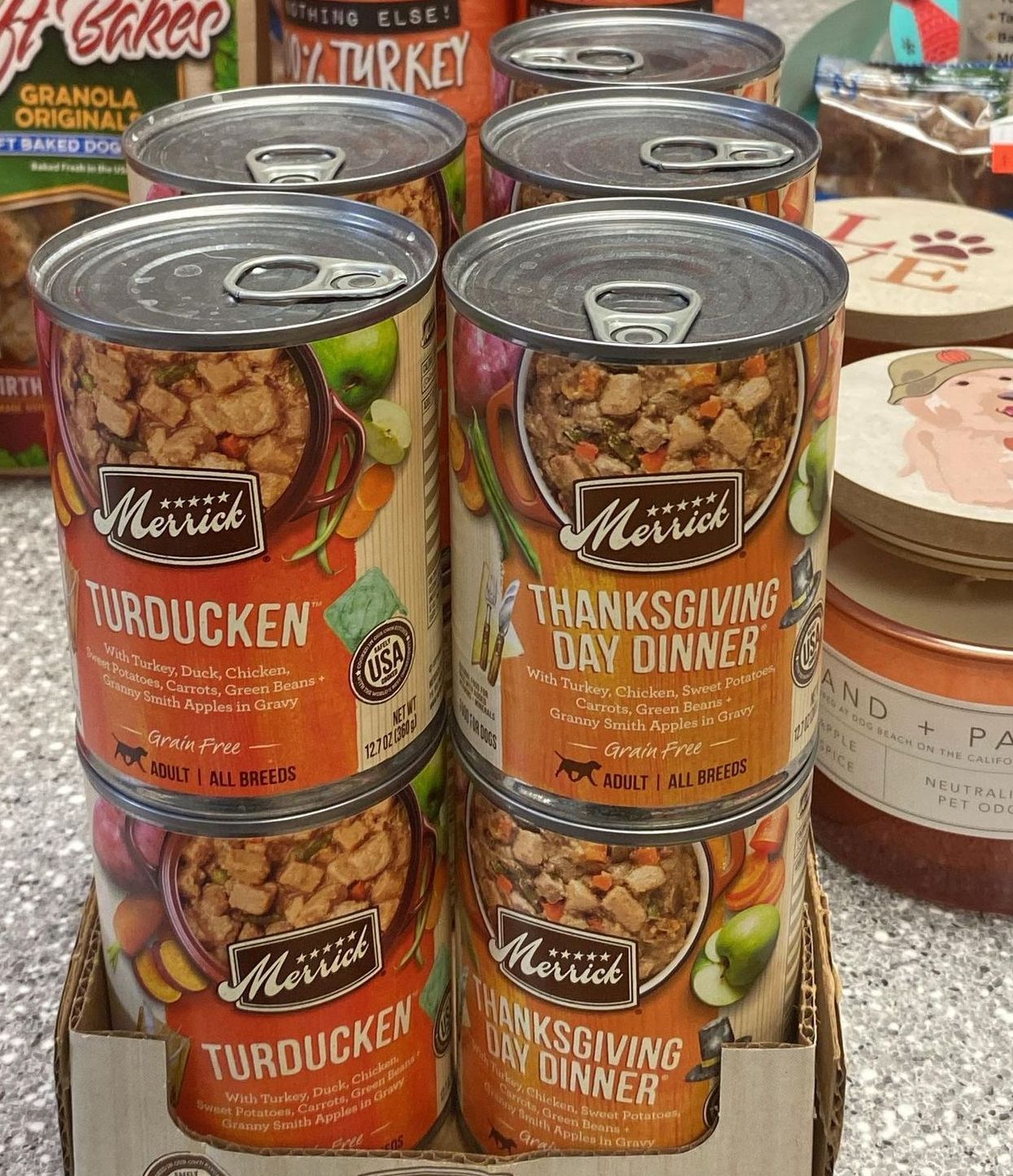 A bunch of cans of food are stacked on top of each other on a table.