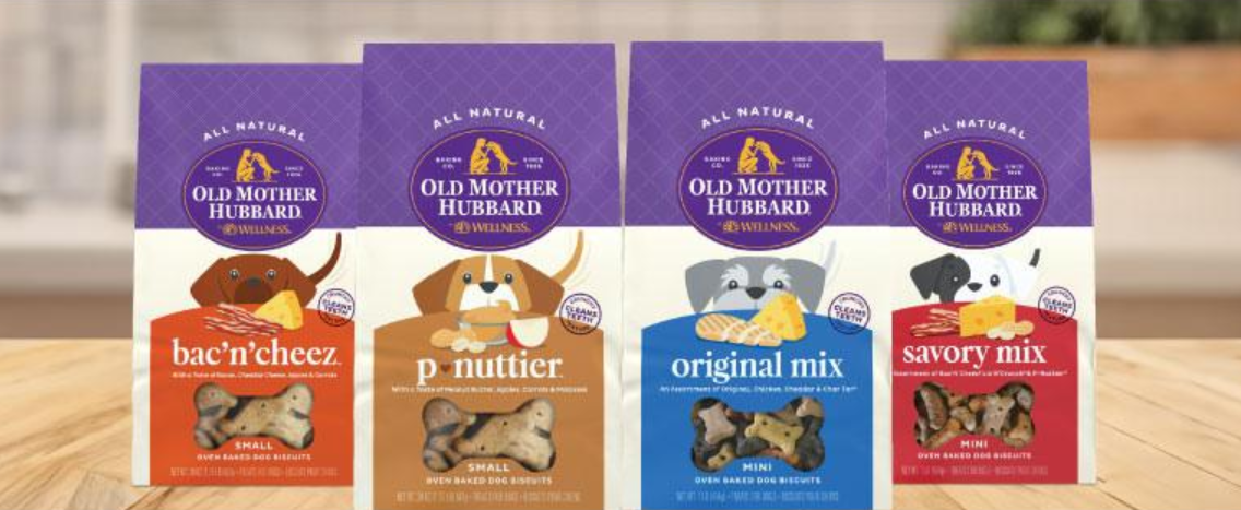 Four boxes of dog treats are sitting on a wooden table