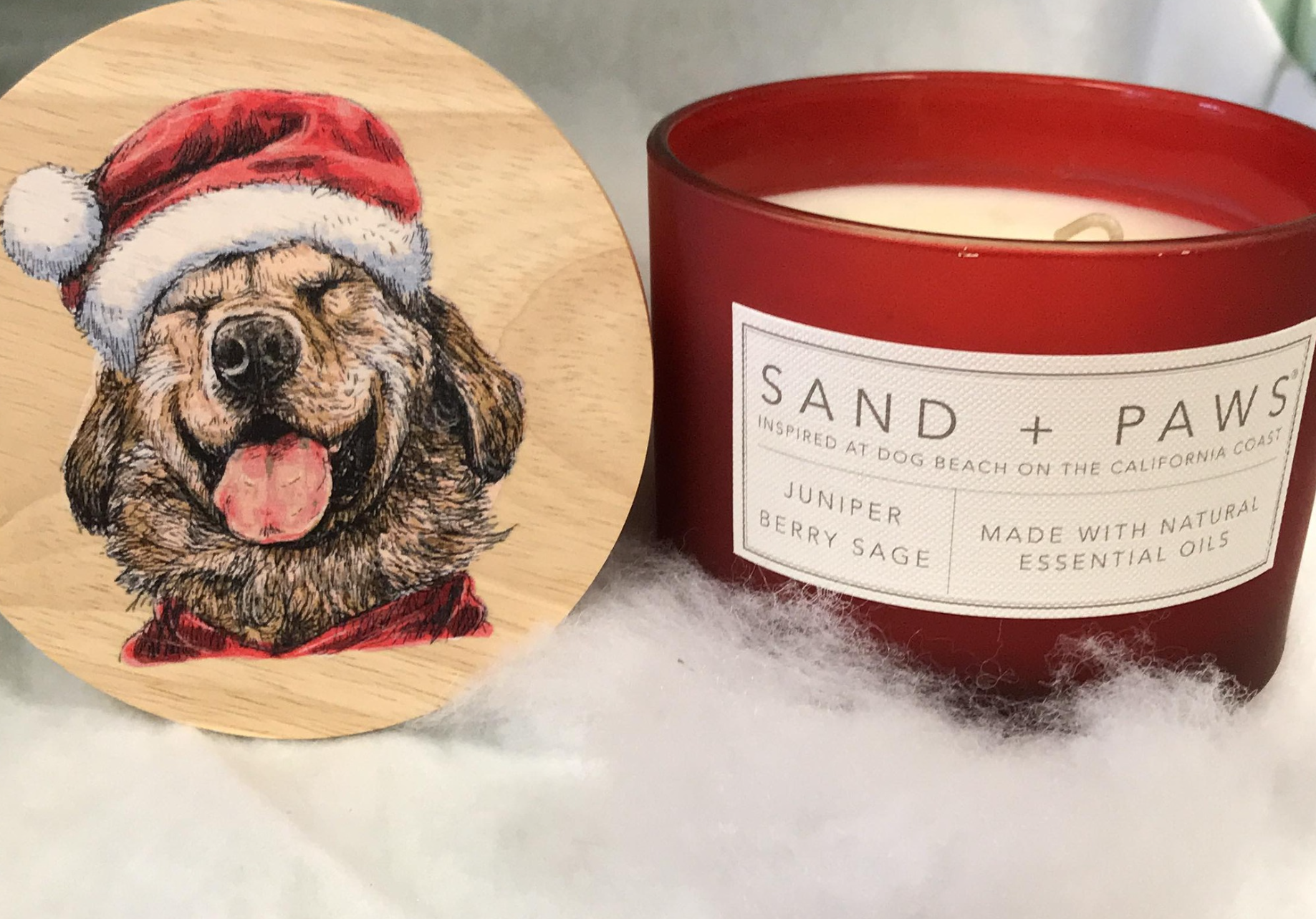 A candle with a picture of a dog wearing a santa hat