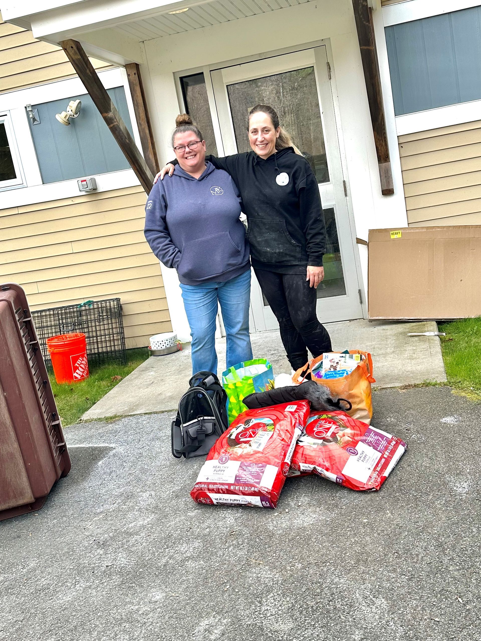 Fran Murphy stands outside Better Together Dog Rescue with a collection of supplies.