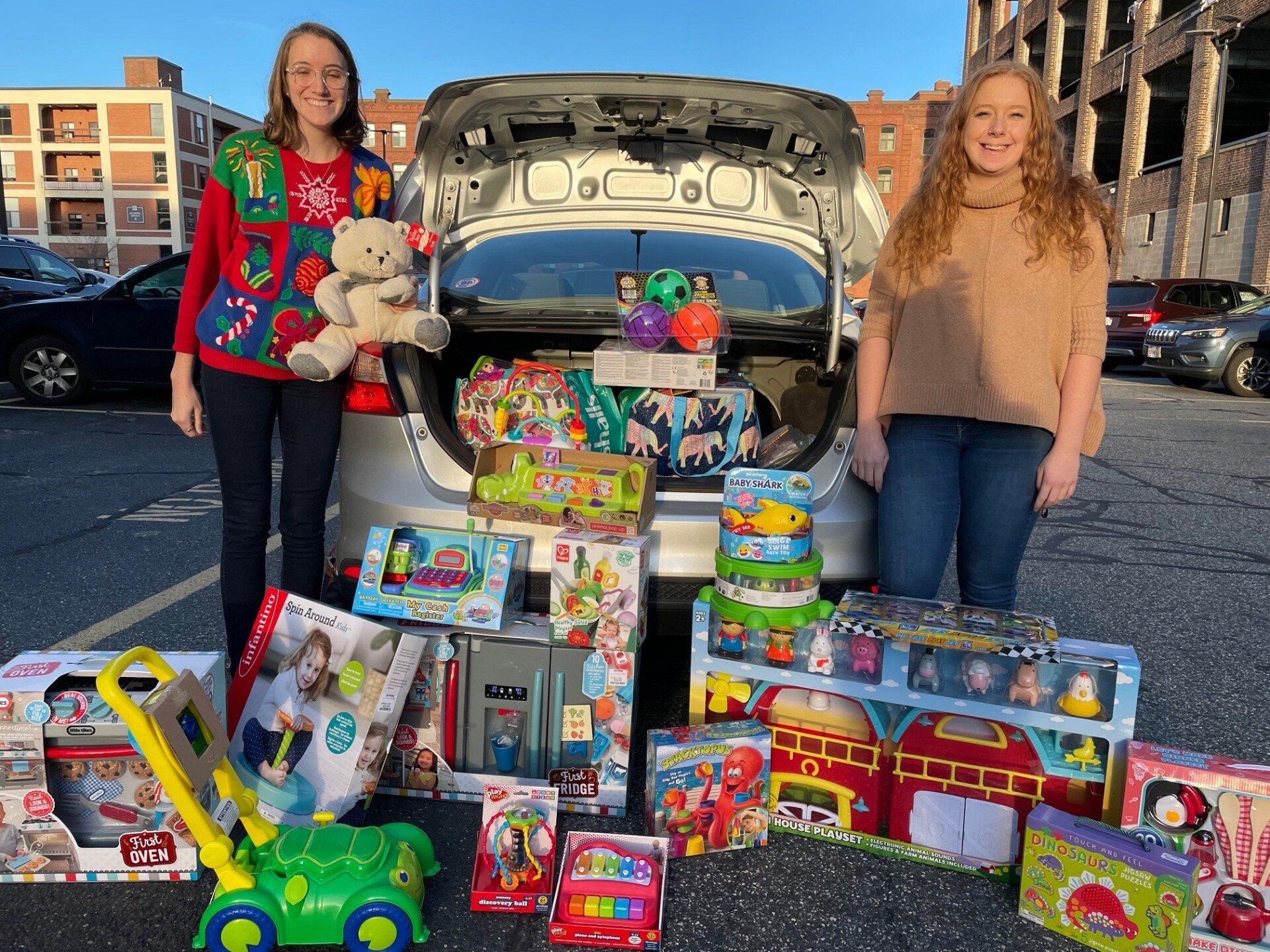 MBK Staff, Kelly and Mia stand with some of the toys MBK bought for a Toy Drive for Square One