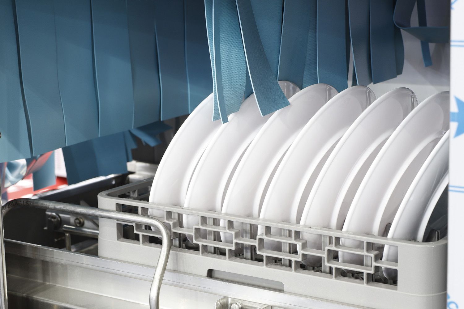 A dishwasher is filled with white plates and cups.