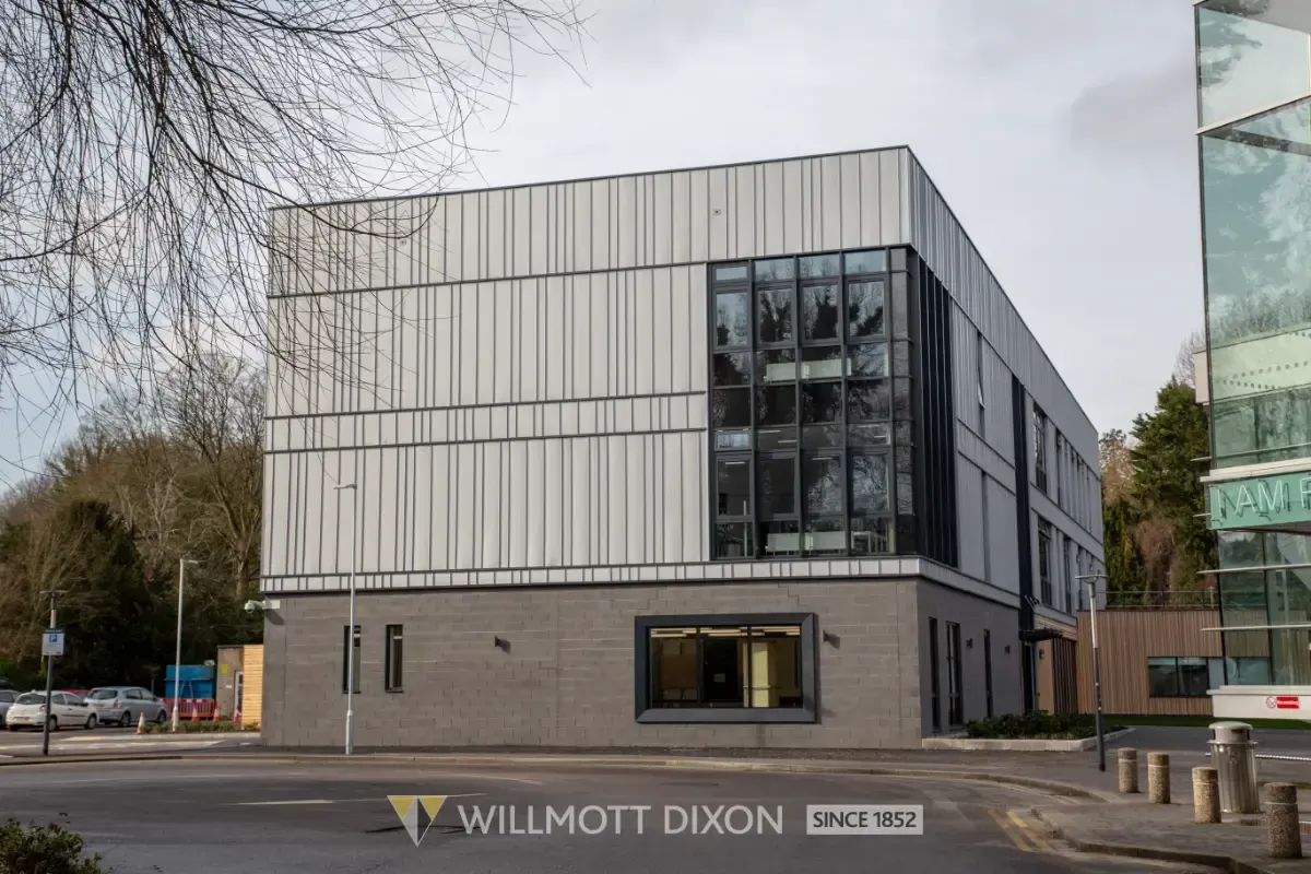 Modern gray office building with large windows and a “Wilmott Dixon” sign on the corner