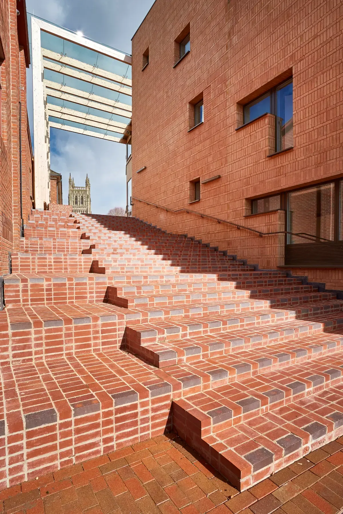 Brick stairway between brick buildings with blue sky visible above