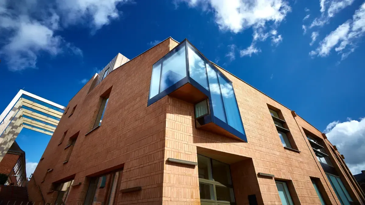 Brick building with blue glass windows against a bright sky