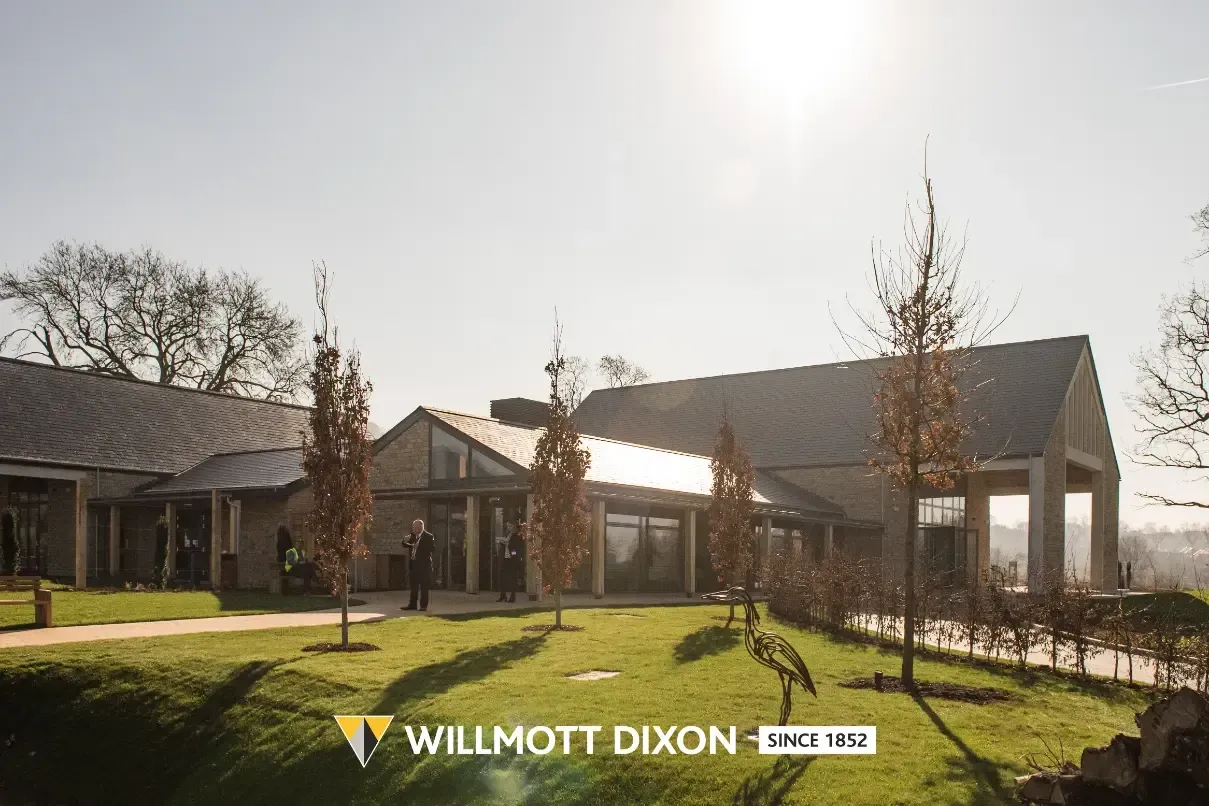 Modern house exterior with landscaped lawn, trees, and bright sunlight