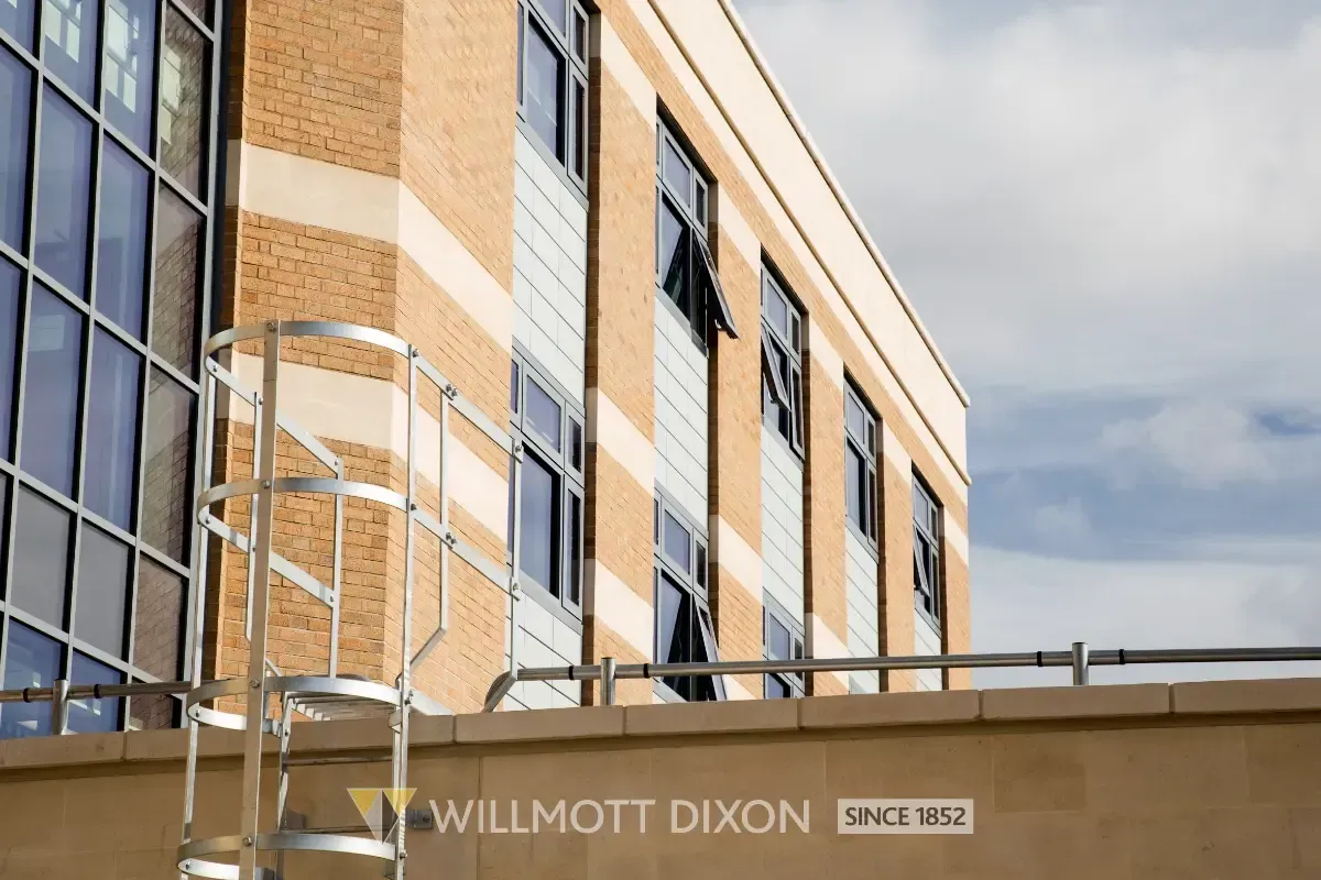 Modern tan-brick office building with tall windows and a Willmott Dixon sign