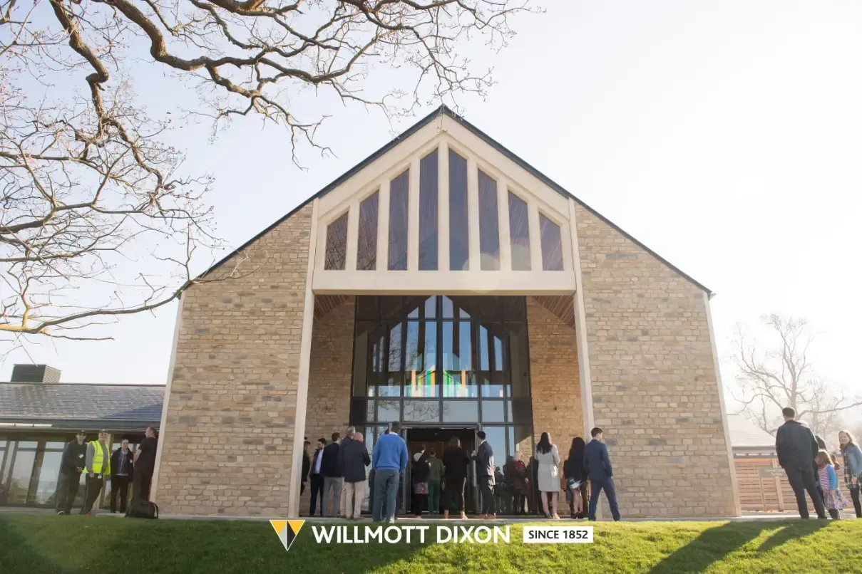 People standing at a church entrance with a WILLIAM DIXON banner in front
