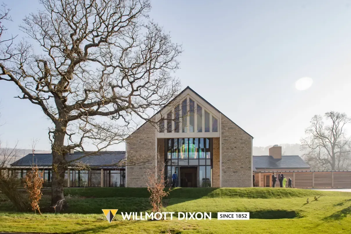 Modern stone building with large windows and bare trees on a grassy lawn, W.M. Dixon logo visible