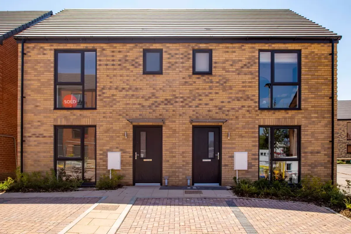 Front view of a modern brick townhouse with two dark doors and large windows