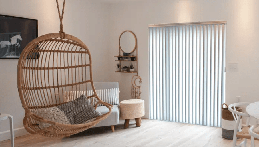 a living room with norman shutters, a hanging chair and a couch Love is Blinds Missouri (314) 808-3440.
