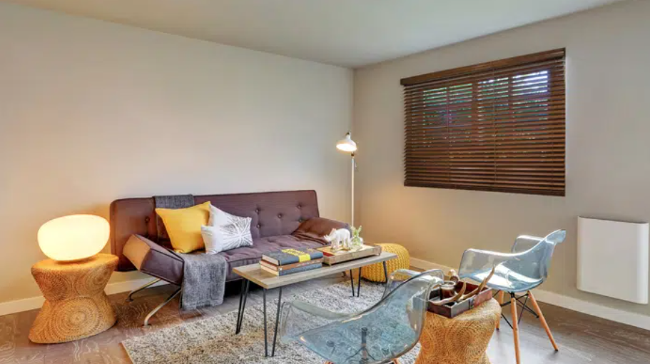 a living room with a couch , table , chairs and a window with norman shutters Love is Blinds Missouri (314) 808-3440.