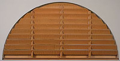 Love is Blinds St. Louis: A close up of a curved window with custom window wooden blinds. 