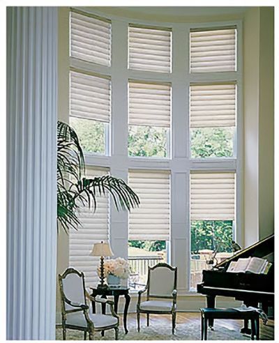 Love is Blinds St. Louis: A living room with a piano and lots of windows with plantation shutters.