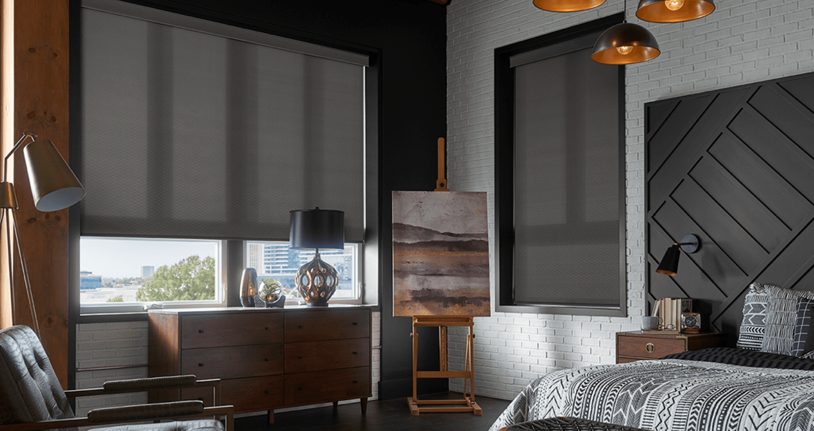 a bedroom with window shades, a bed , chair , dresser , and a painting on an easel Love is Blinds Missouri (314) 808-3440.