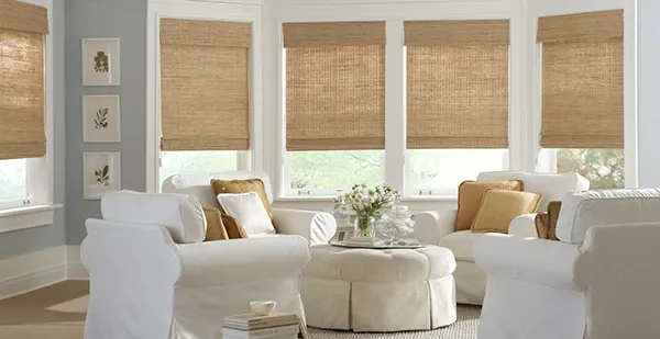 a living room filled with furniture, a round ottoman and Roman shades Love is Blinds Missouri (314) 808-3440.