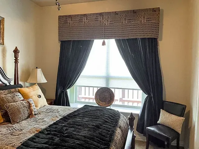 Love is Blinds St. Louis: A living room with a chair and a window with cellular shades.