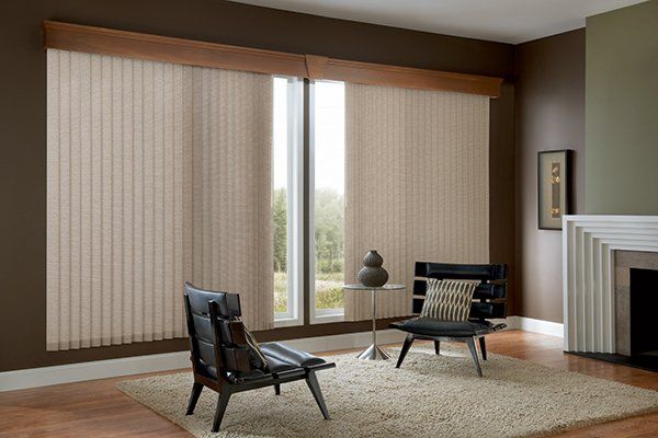 a living room with vertical blinds , a chair , a table and a fireplace Love is Blinds Missouri (314) 808-3440.