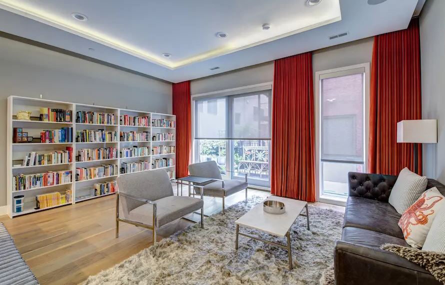 a living room filled with furniture and a bookshelf and custom window shades Love is Blinds Missouri (314) 808-3440.