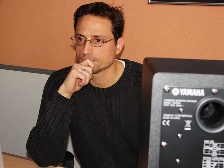 Al, resting chin, looking pensively near a Yamaha speaker.