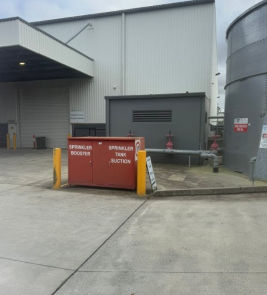 Sprinkler Booster Cabinet Beside Warehouse And Fire Water Tank &mdash; Commercial Leak Detection in Mudgeeraba, QLD