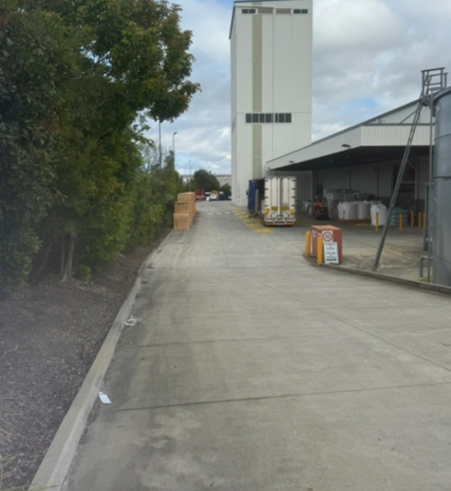 Concrete Driveway Beside Industrial Warehouse And Tall Silo &mdash; Commercial Leak Detection in Mudgeeraba, QLD