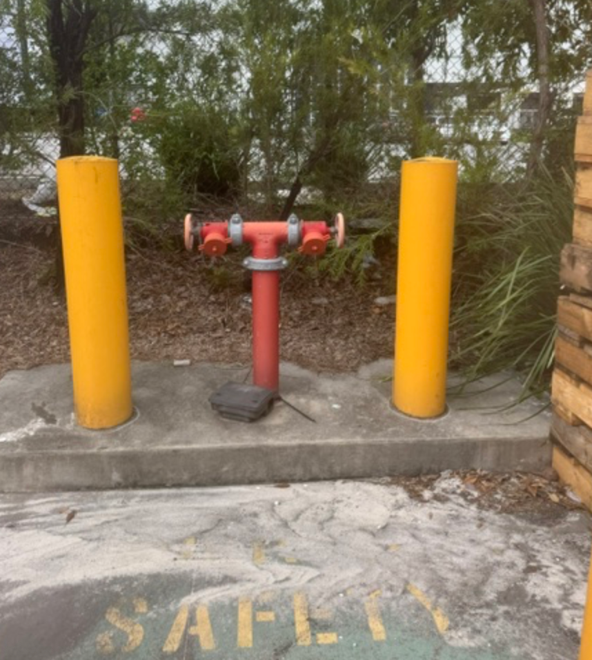 Red Fire Hydrant Standpipe Between Two Yellow Bollards &mdash; Commercial Leak Detection in Mudgeeraba, QLD