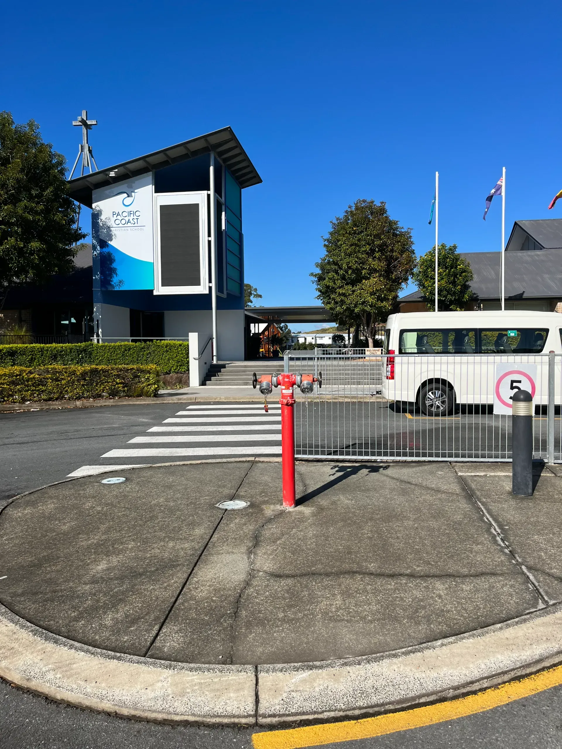 Exterior view of building with a bus and a fire hydrant. Crosswalk and 5 mph sign are visible.  — Commercial Leak Detection
